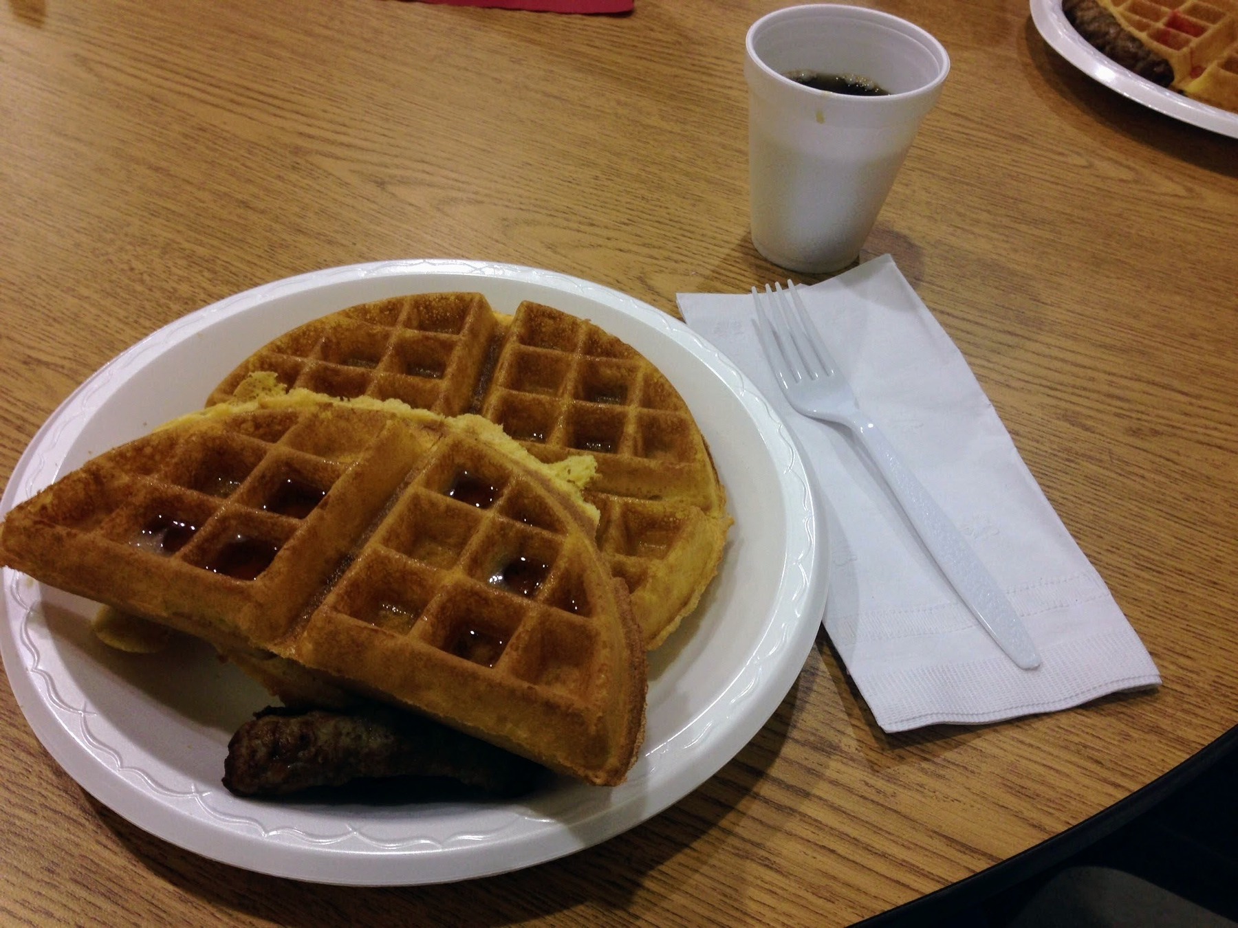 A picture of a waffle next to a cup of coffee